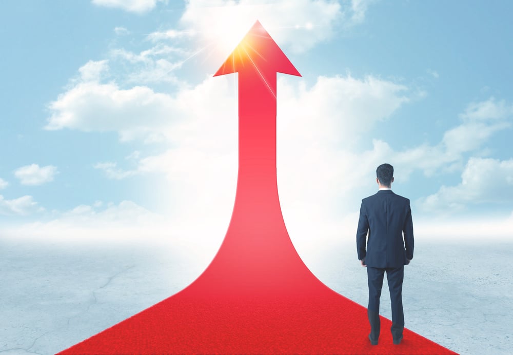Concept of the road to success with a businessman standing on a red arrow